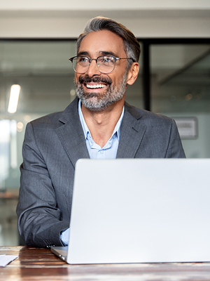 A guy smiling while on his computer. 