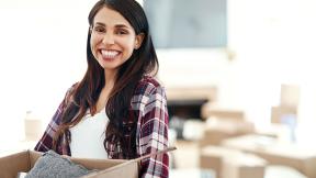 A girl smiling while packing up her house. 