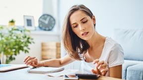 A girl doing calculations for her budget. 